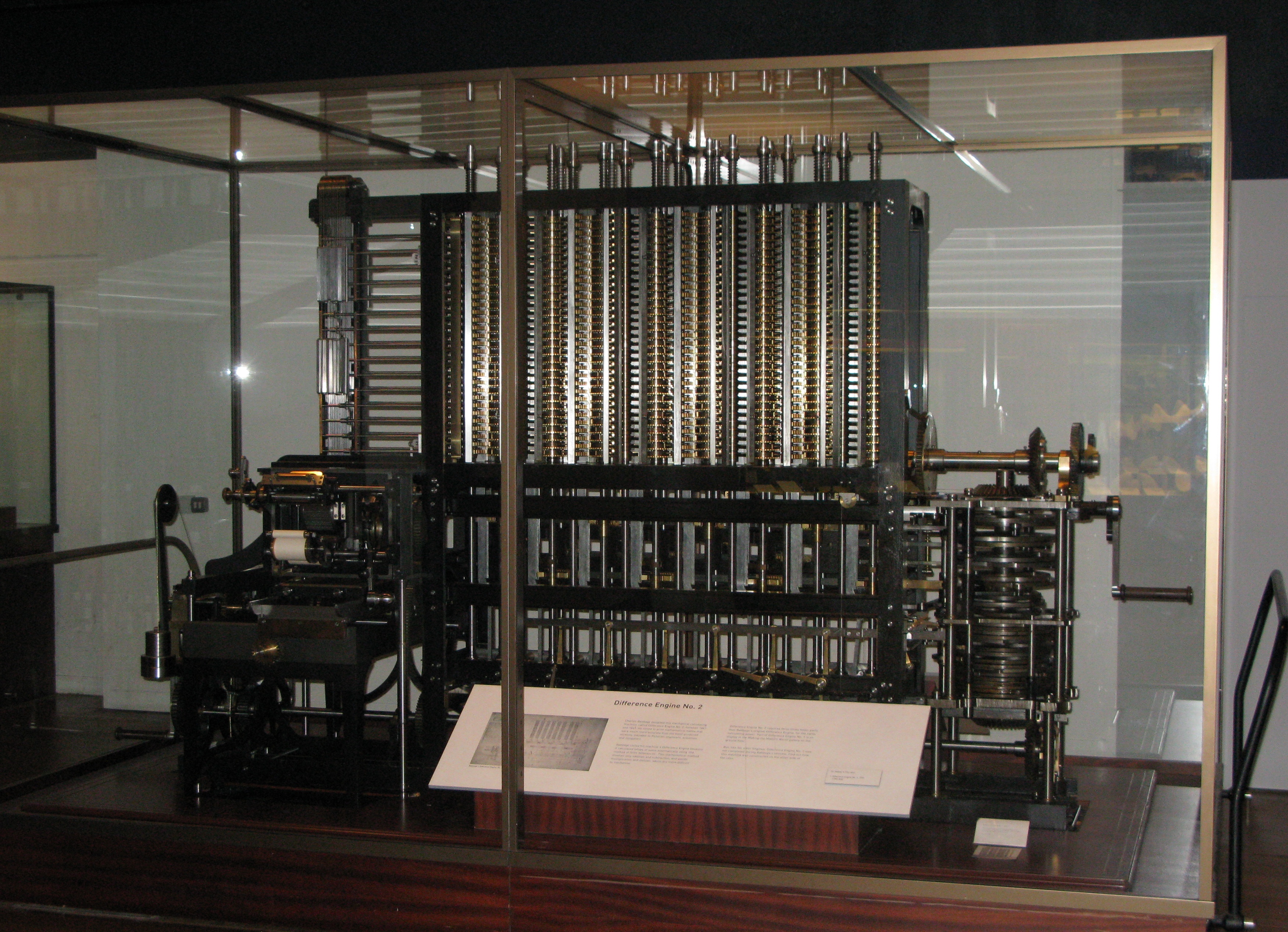 The Difference Engine at the London Science Museum: the image shows a large mechanical device with many gears and a large crank on the side.